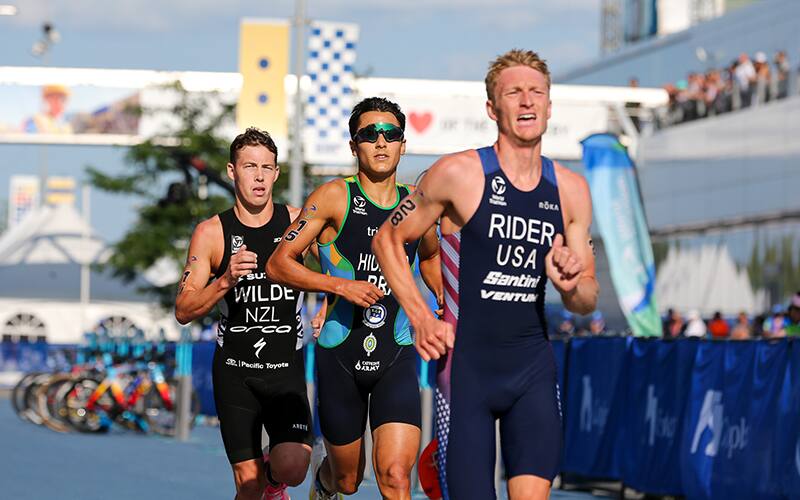 photo of elite u.s. triathlete Seth Rider running while wearing a blue USA kit with his last name on the front