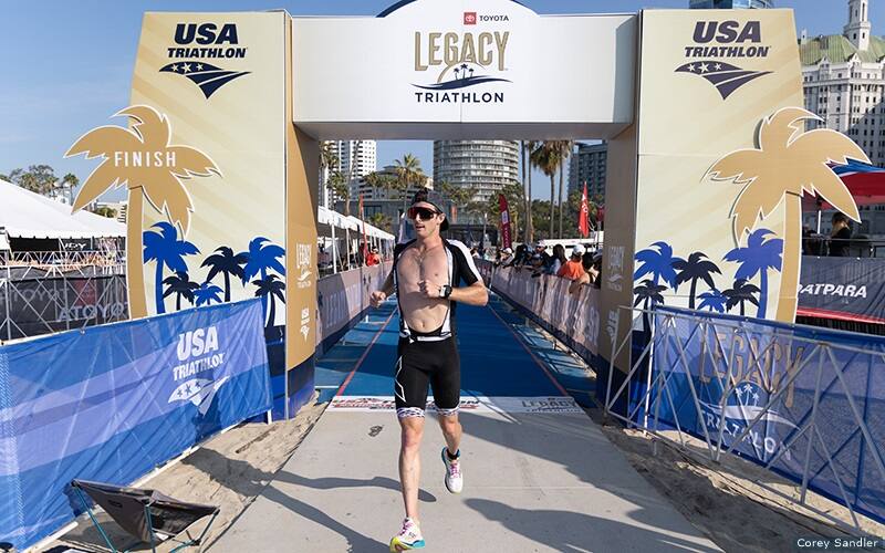 man crossing the finish line of the toyota legacy triathlon