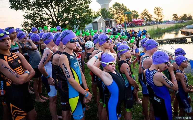 youth athletes lined up at the beach before the start of their race