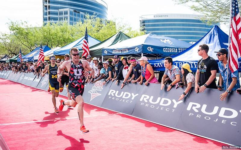 a group of three athletes, wearing their college kits, run toward the finish line at collegiate club nationals in tempe arizona