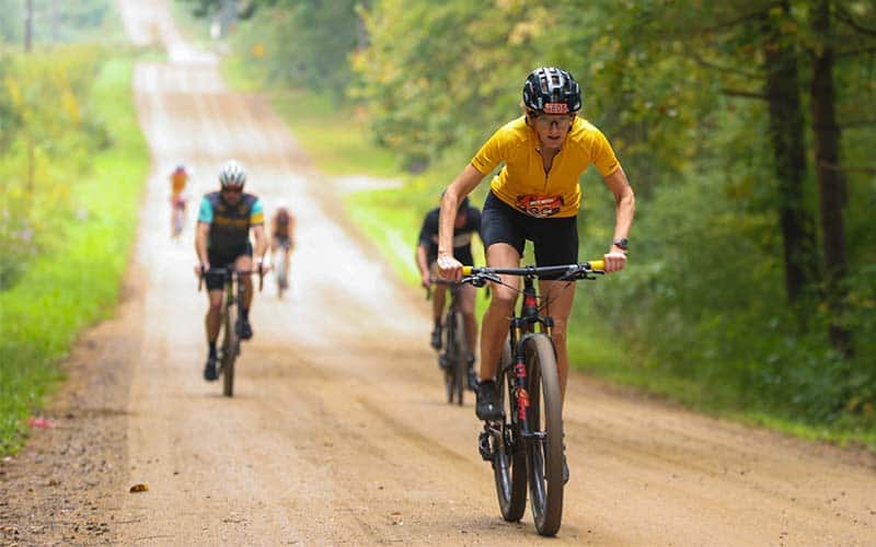 bikers ride on a gravel road at The Dirty Mitten gravel triathlon in Michigan