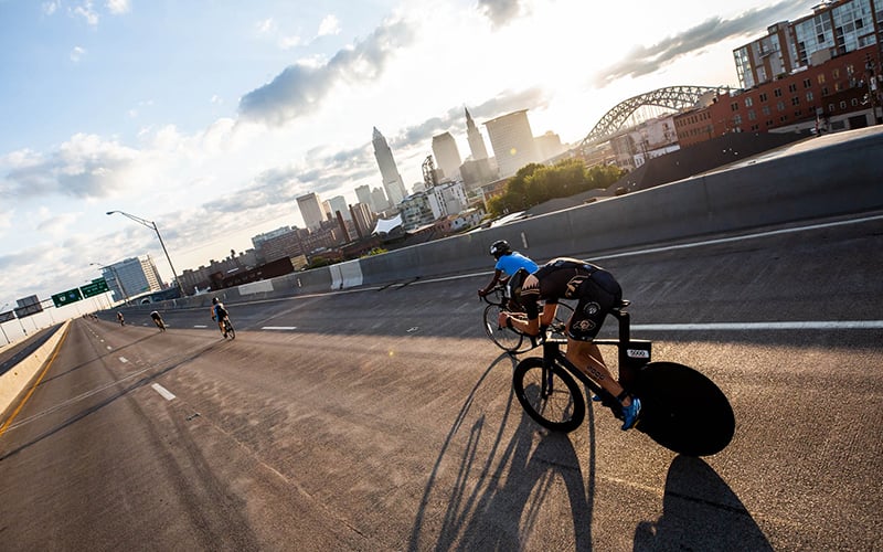 Men riding bikes over a bridge