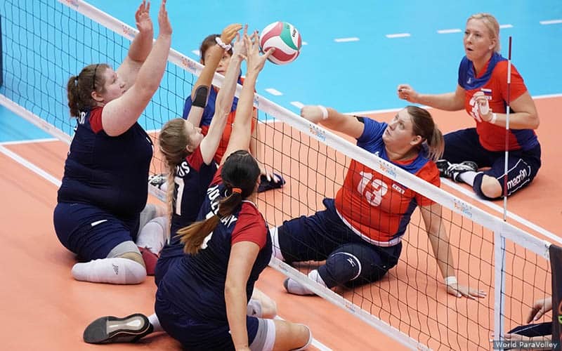 Tia Edwards (middle blocker) and Katie Holloway lead a Team USA triple block against Russia