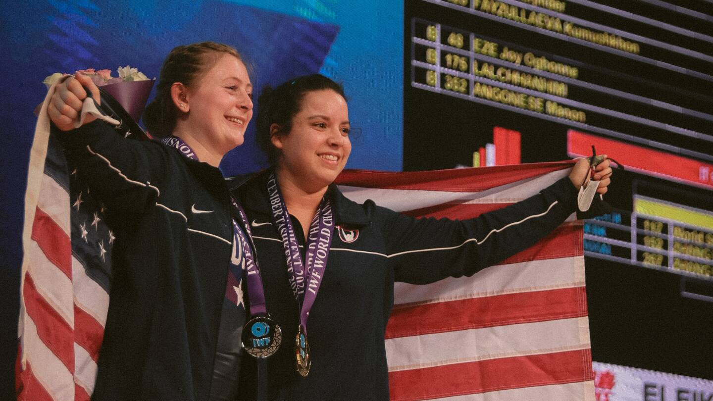 Olivia Reeves and Meredith Alwine pose for a photo with their world championships medals and American flags