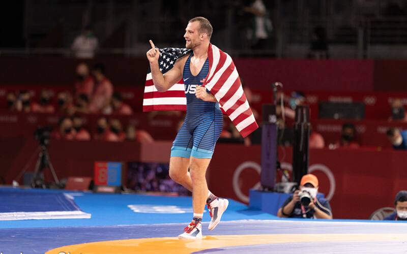 David Taylor of the USA with the flag on his shoulders and pointing No. 1 after Olympic gold victory