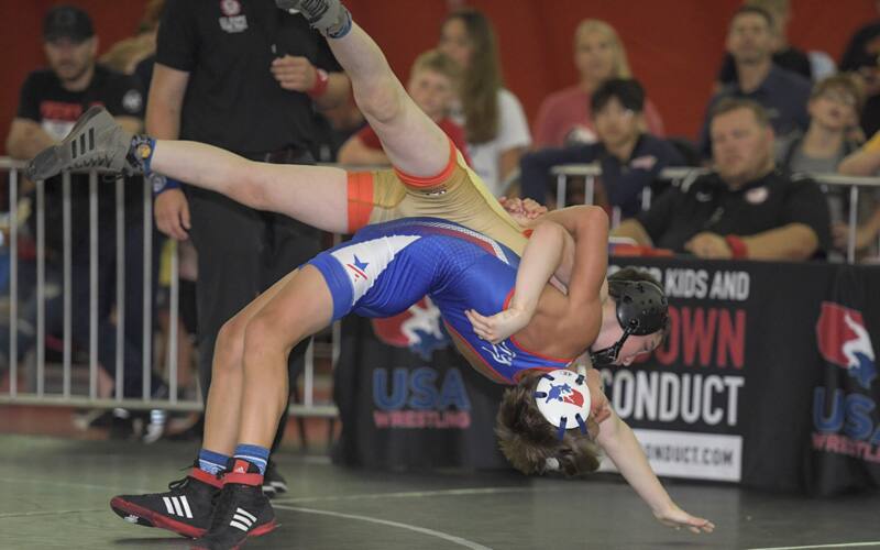 A youth wrestler hits a back souplesse throw at the 2021 Kids Nationals, with a back arch and high amplitude