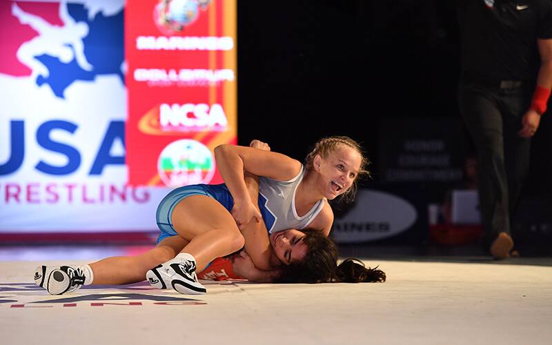 Sage Mortimer smiles to her coaches in the corner after throwing her opponent to her back. 