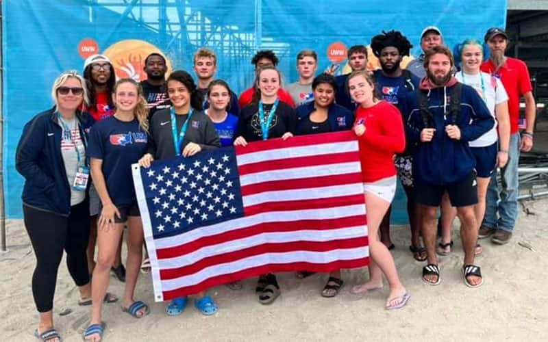 Members of the 2022 U.S. Beach delegation pose together in the sand at Mamaia Beach in Romania. 