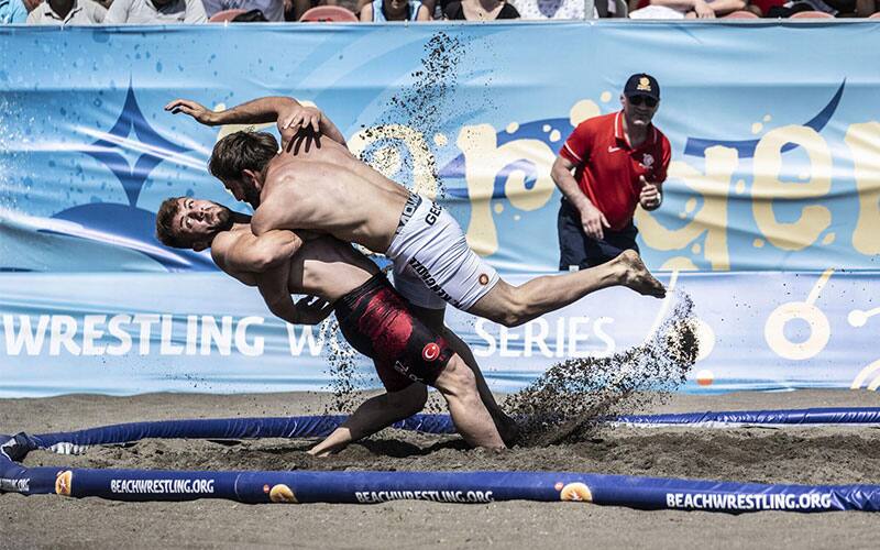 Men's Beach Wrestling action photo, one athlete throws another