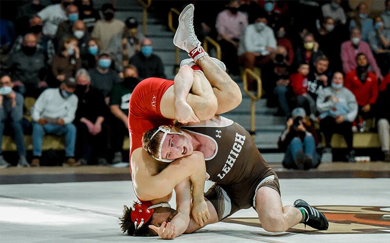 A Lehigh wrestler looks to finish a takedown on the mat against Cornell