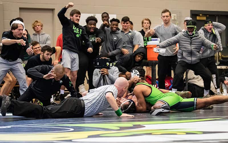 The sideline goes wild during a pin at an NAIA wrestling match