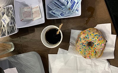 A black coffee and sprinkled donut