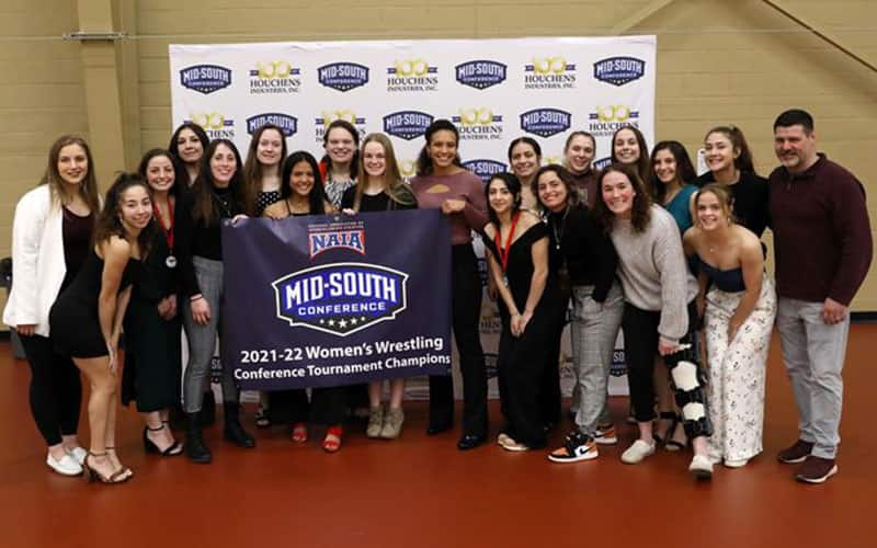 Campbellsville women's wrestling team with its 2022 Mid-South Conference champion banner