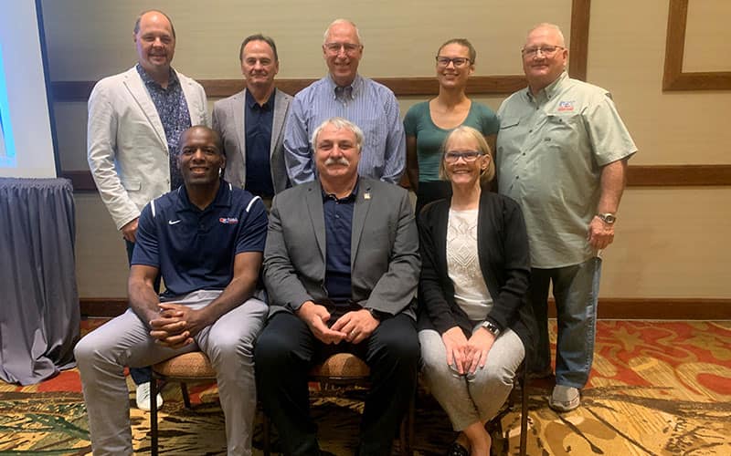 Eight USA Wrestling leaders pose together at the 2022 Board of Directors meeting