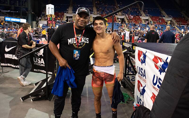 Daniel Cormier poses with a wrestler