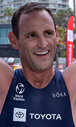 eric mcelvenny holding finish line tape above head